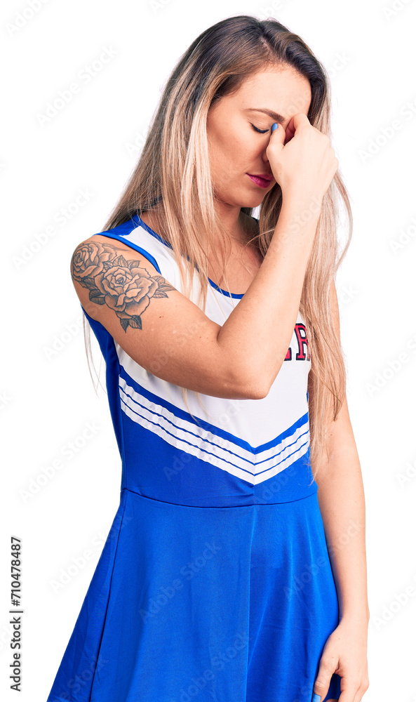 Young beautiful blonde woman wearing cheerleader uniform tired rubbing nose and eyes feeling fatigue and headache. stress and frustration concept. Young beautiful blonde woman wearing cheerleader uniform tired rubbing nose and eyes feeling fatigue and headache. stress and frustration concept.