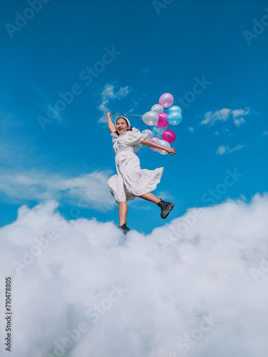 Woman smiling and jumping holding balloons © Kanbokeh