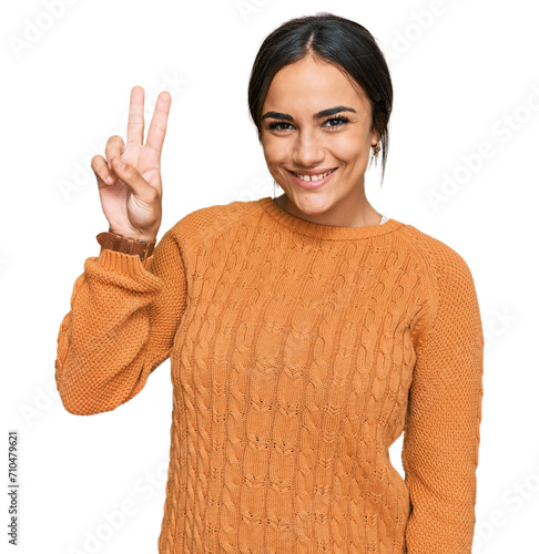 Young brunette woman wearing casual winter sweater showing and pointing up with fingers number two while smiling confident and happy.