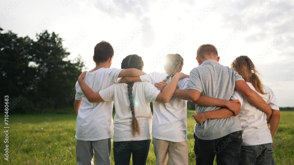Happy family concept. children in kindergarten on walk in park. kids smiling and hugging in fresh air. games in kindergarten on green grass. active games outdoors at sunset. happy children. friendship Happy family concept. children in kindergarten on walk in park. kids smiling and hugging in fresh air. games in kindergarten on green grass. active games outdoors at sunset. happy children. friendship