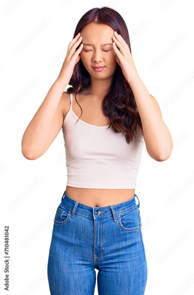 Young beautiful chinese girl wearing casual clothes with hand on head for pain in head because stress. suffering migraine. Young beautiful chinese girl wearing casual clothes with hand on head for pain in head because stress. suffering migraine.