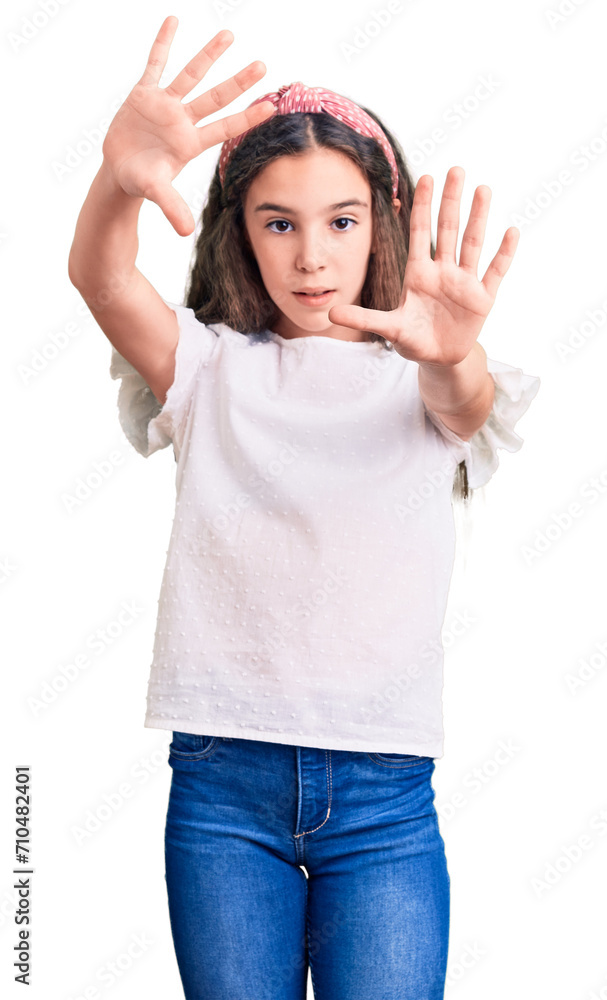 Cute hispanic child girl wearing casual white tshirt doing frame using hands palms and fingers, camera perspective Cute hispanic child girl wearing casual white tshirt doing frame using hands palms and fingers, camera perspective