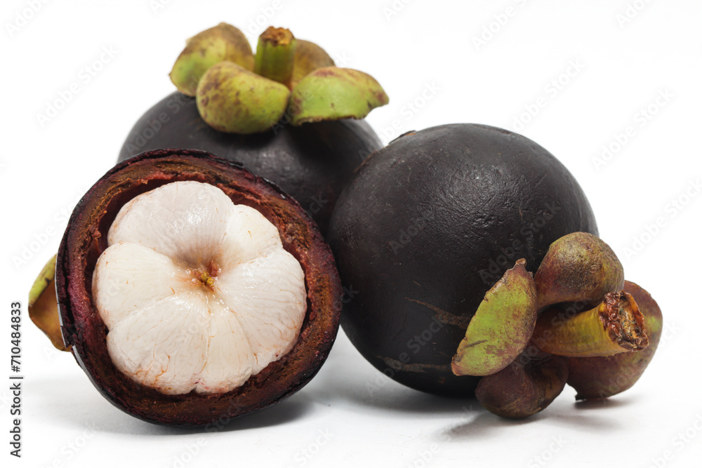 Fototapeta premium Half cut sliced and two whole fresh organic mangosteen delicious fruit isolated on white background clipping path