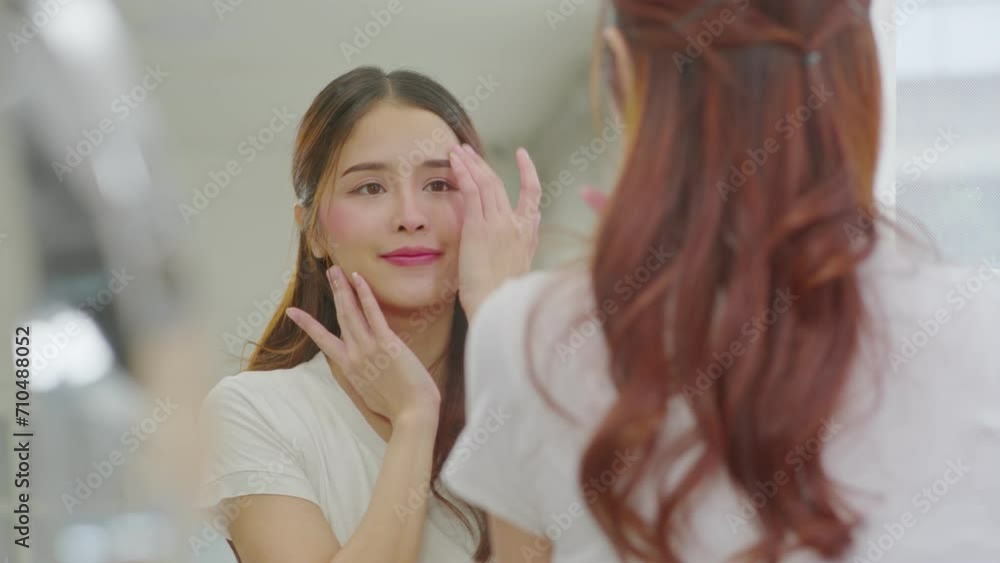 Back view of beautiful Asian young woman looking in the mirror after wake up preparing skin for make up. Healthy female looking her self in mirror smile and happiness with healthy skin. Self Care Back view of beautiful Asian young woman looking in the mirror after wake up preparing skin for make up. Healthy female looking her self in mirror smile and happiness with healthy skin. Self Care
