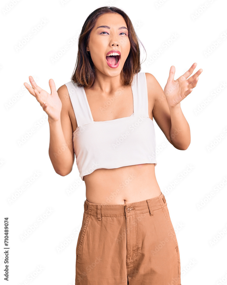 Young beautiful chinese girl wearing casual clothes crazy and mad shouting and yelling with aggressive expression and arms raised. frustration concept. Young beautiful chinese girl wearing casual clothes crazy and mad shouting and yelling with aggressive expression and arms raised. frustration concept.
