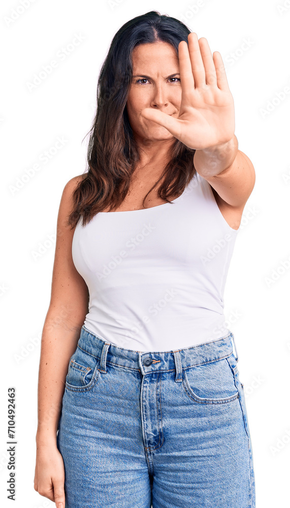 Young beautiful brunette woman wearing casual sleeveless t-shirt doing stop sing with palm of the hand. warning expression with negative and serious gesture on the face. Young beautiful brunette woman wearing casual sleeveless t-shirt doing stop sing with palm of the hand. warning expression with negative and serious gesture on the face.