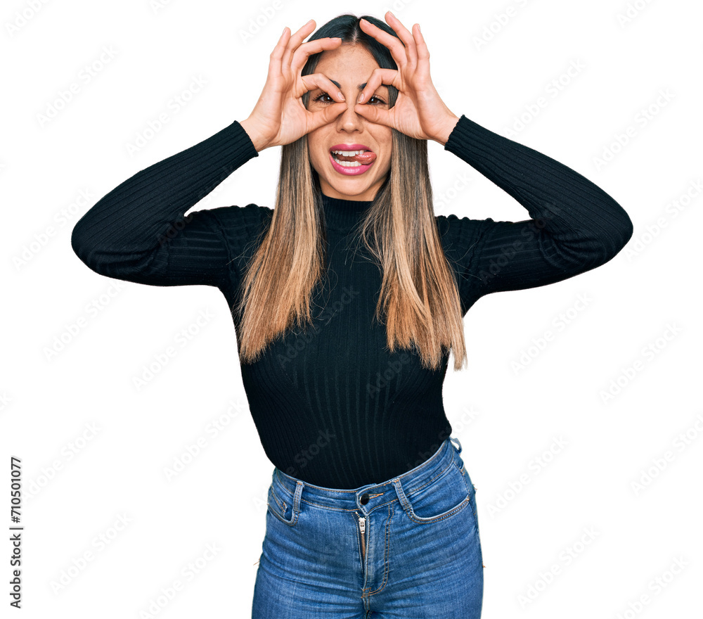 Young hispanic woman wearing casual clothes doing ok gesture like binoculars sticking tongue out, eyes looking through fingers. crazy expression. Young hispanic woman wearing casual clothes doing ok gesture like binoculars sticking tongue out, eyes looking through fingers. crazy expression.