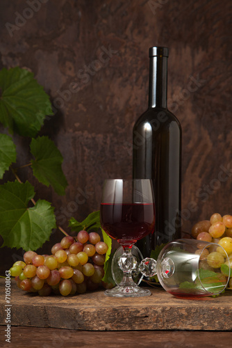 Still life with glasses of red wine and grapes on vintage wooden background..