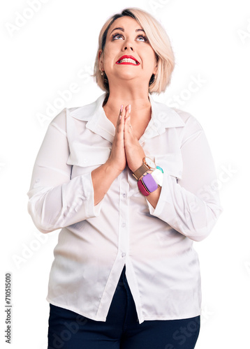 Young blonde plus size woman wearing casual shirt begging and praying with hands together with hope expression on face very emotional and worried. begging.