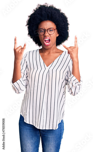 Young african american woman wearing casual clothes and glasses shouting with crazy expression doing rock symbol with hands up. music star. heavy concept.