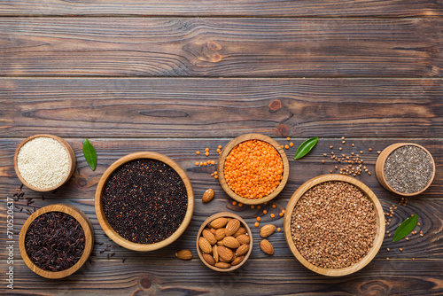 Various superfoods in smal bowl on colored background. Superfood as rice, chia, quinoa, lentils, nuts, sesame seeds, almonds. top view copy space photo
