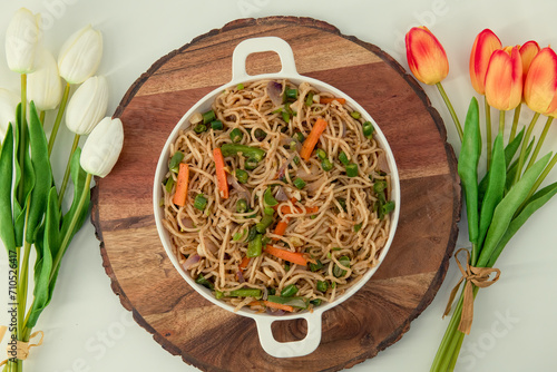 Tasty Vegetable hakka noodles in white plate and isolated background. Indo-Chinese vegetarian cuisine dish. Indian veg noodles with vegetables. Classic Asian meal..