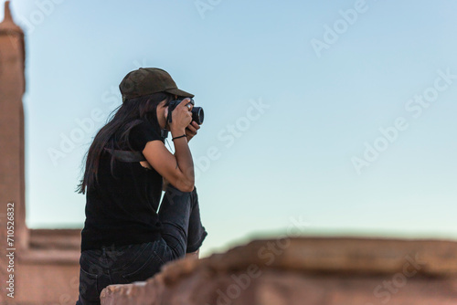 View of a western European woman taking photos at sunset in Ait Benhaddou, a small berber village on the High Atlas mountains, Central Morocco. photo