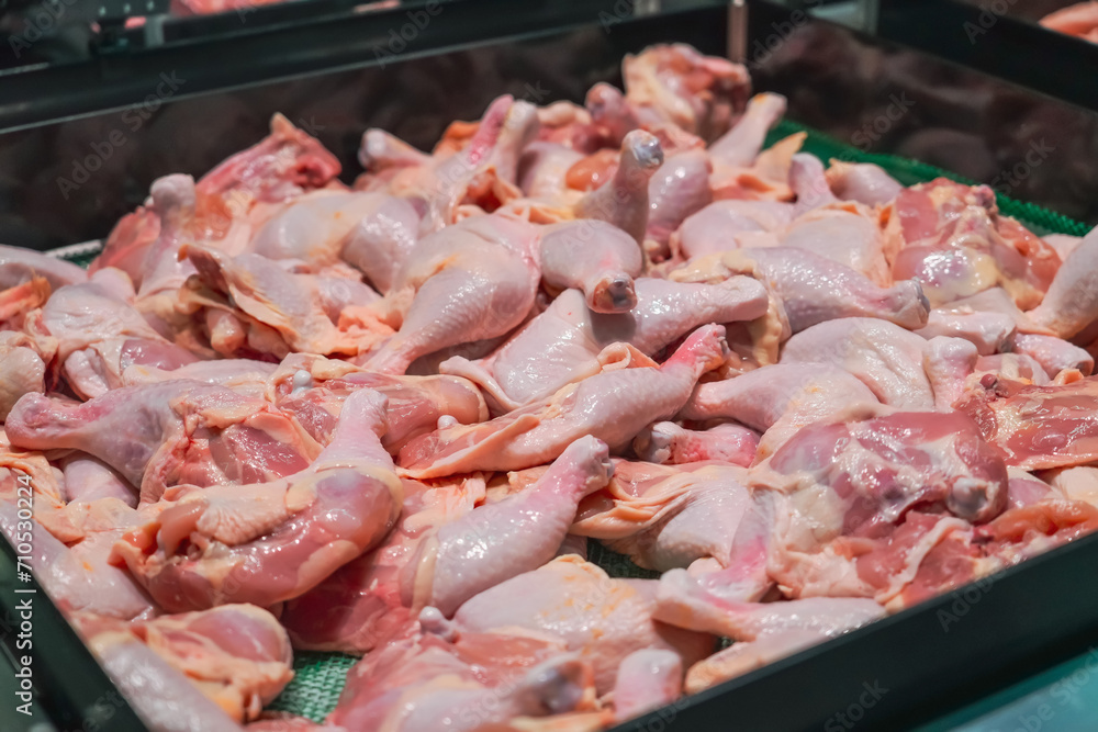 Chicken meat, raw - breast fillet, wings and legs of the bird's paws in containers on store shelves. Legs of chicken