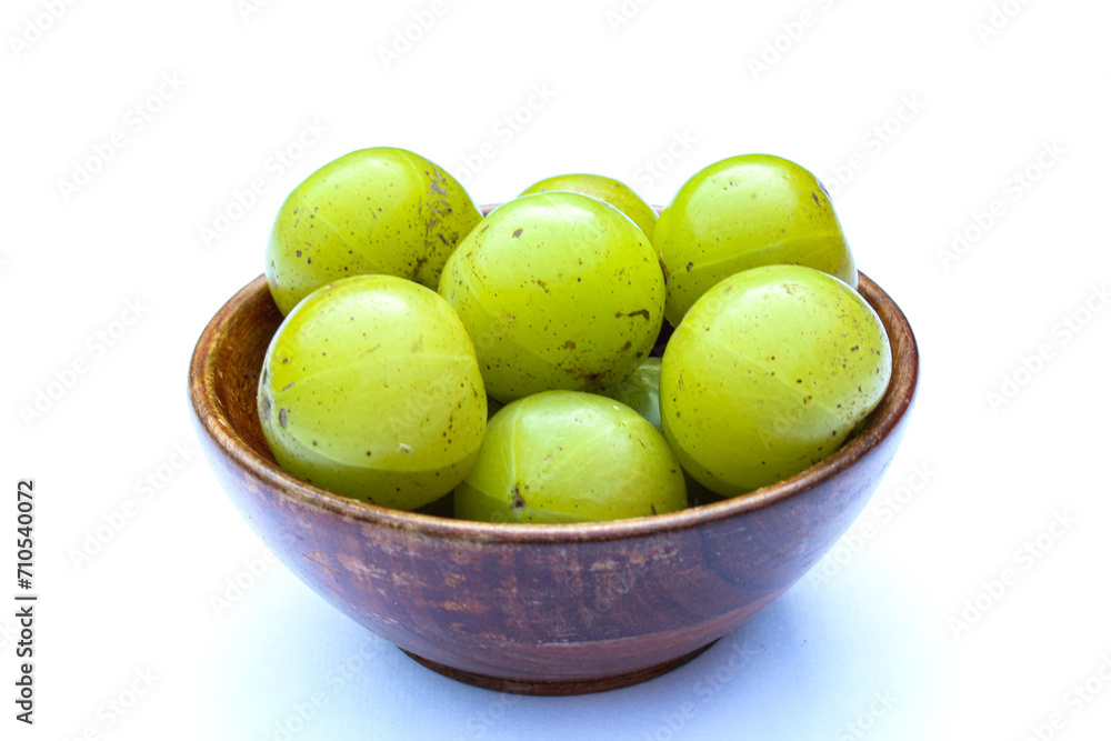 Phyllanthus emblica or Indian gooseberry fruits in a wooden bowl Phyllanthus emblica or Indian gooseberry fruits in a wooden bowl