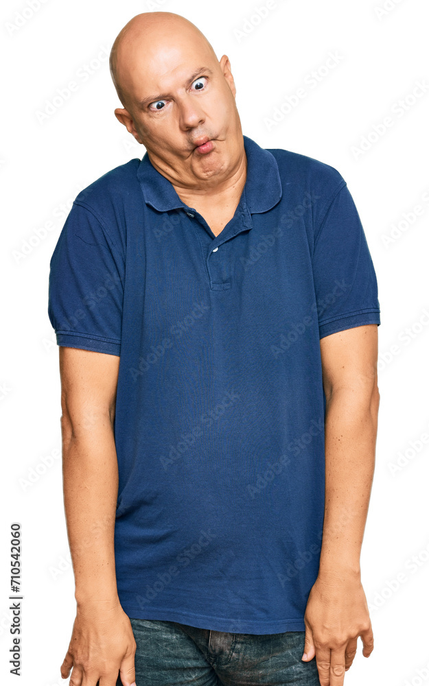 Middle age bald man wearing casual clothes making fish face with lips, crazy and comical gesture. funny expression. Middle age bald man wearing casual clothes making fish face with lips, crazy and comical gesture. funny expression.