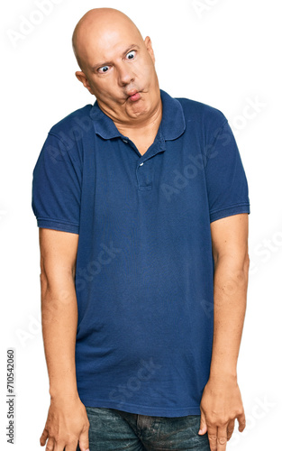 Middle age bald man wearing casual clothes making fish face with lips, crazy and comical gesture. funny expression.