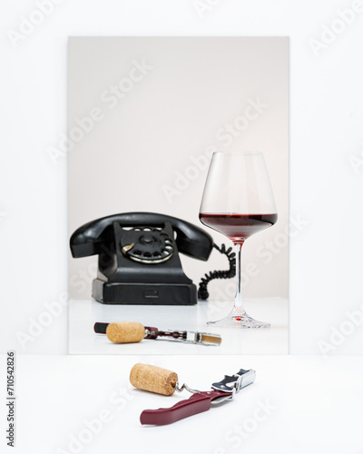 Red wine in a glass and retro style telephone isolated on white background, copy space