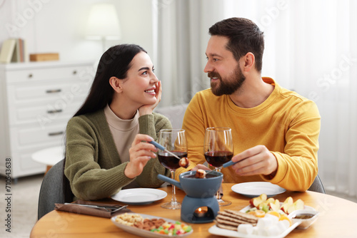 Affectionate couple enjoying chocolate fondue during romantic date at home