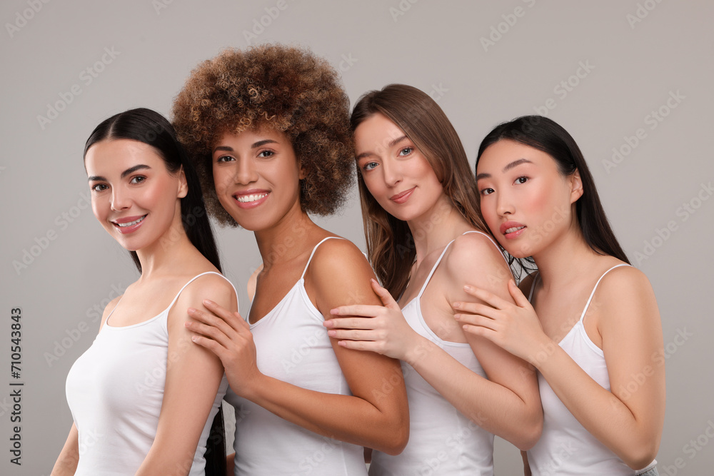 Obraz premium Beautiful young women with healthy skin on gray background