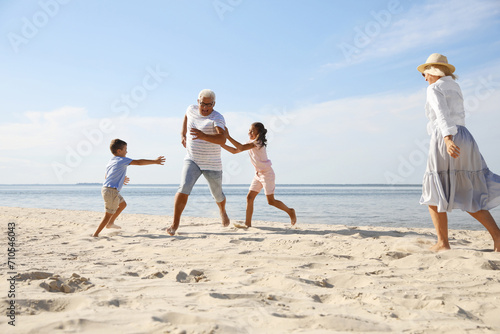 Cute little children with grandparents spending time together on sea beach