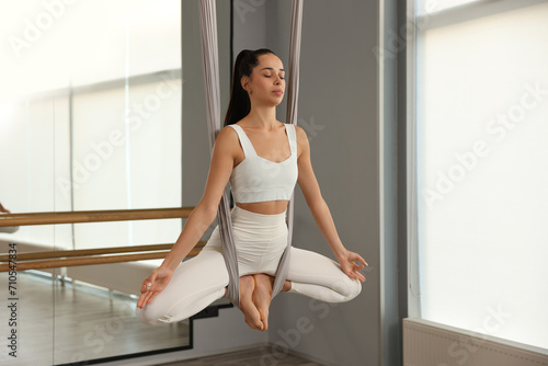 Fotografie Young woman practicing fly yoga on hammock in studio