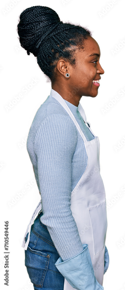 Young african american woman wearing apron looking to side, relax profile pose with natural face with confident smile. Young african american woman wearing apron looking to side, relax profile pose with natural face with confident smile.