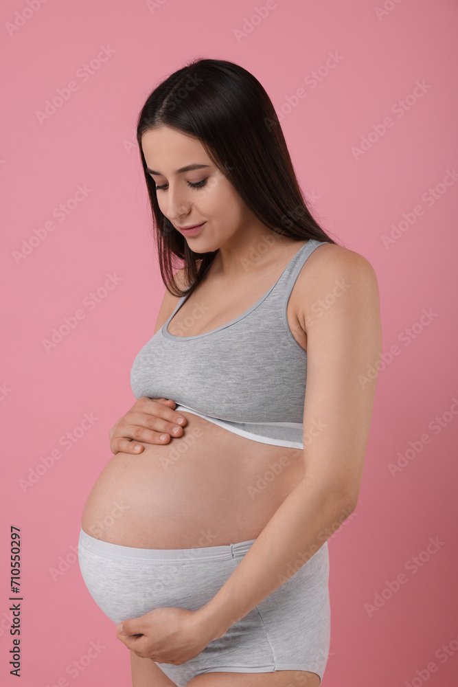 Beautiful pregnant woman in comfortable maternity underwear on pink background Beautiful pregnant woman in comfortable maternity underwear on pink background