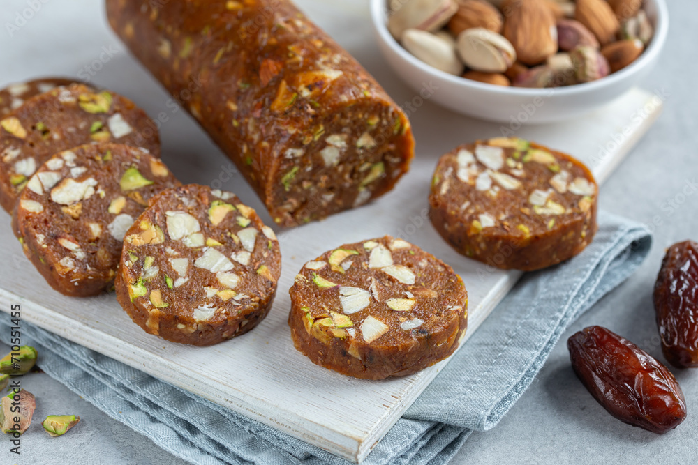 dates nuts roll salami, delicious natural raw vegan dessert, healthy food concept dates nuts roll salami, delicious natural raw vegan dessert, healthy food concept