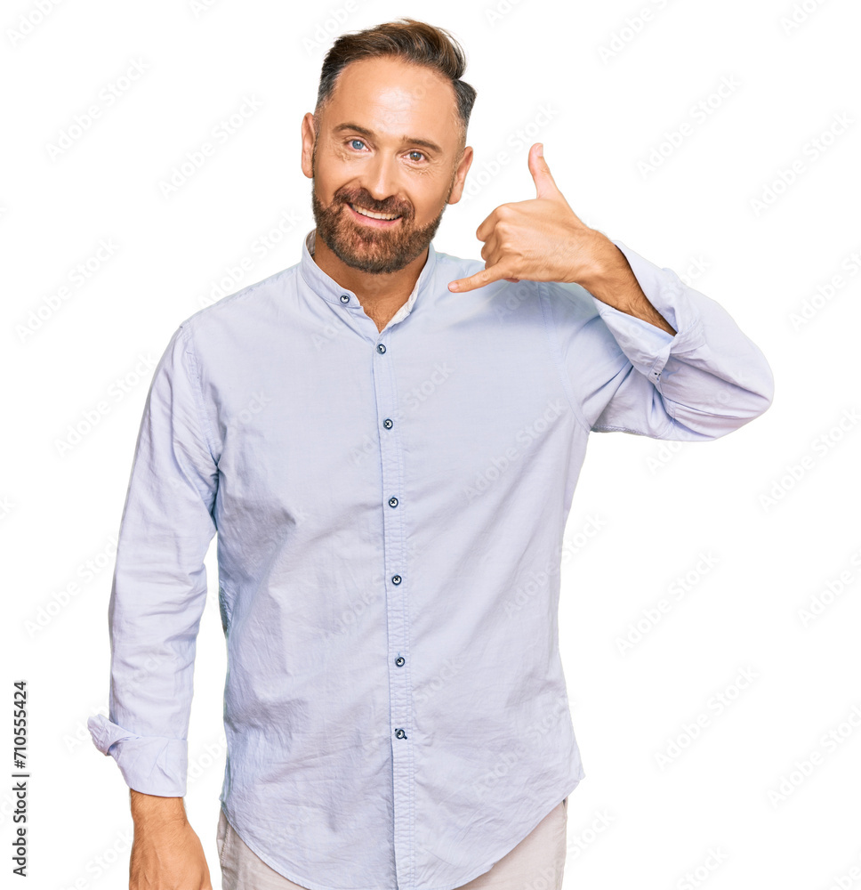 Handsome middle age man wearing business shirt smiling doing phone gesture with hand and fingers like talking on the telephone. communicating concepts. Handsome middle age man wearing business shirt smiling doing phone gesture with hand and fingers like talking on the telephone. communicating concepts.