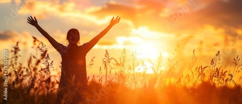 A Silhouette Of A Healthy Woman Raising Her Hands Against Sunset 