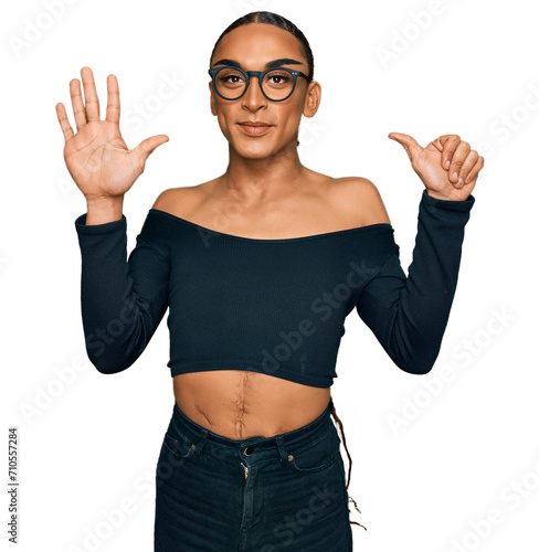 Hispanic transgender man wearing make up and long hair wearing women clothes showing and pointing up with fingers number six while smiling confident and happy.