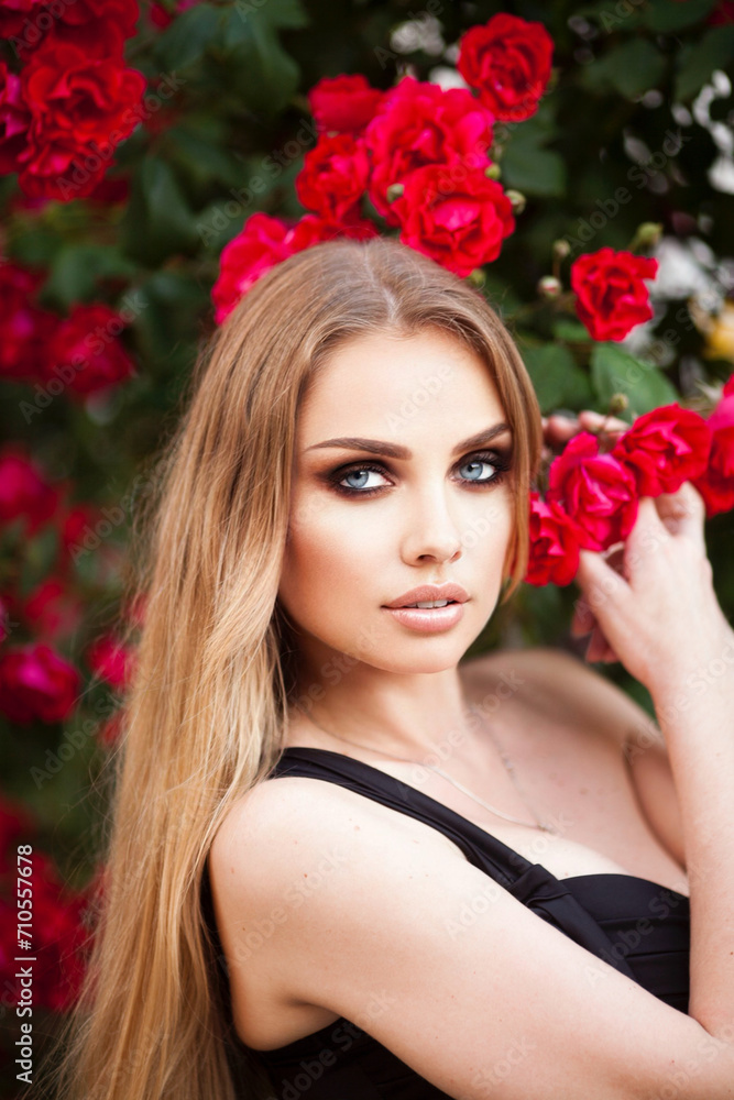 Naklejka premium Young Female Black Top Windy Wavy Hair Portrait in Rose Flower Garden Golden Hour Head Turned Curious Looking