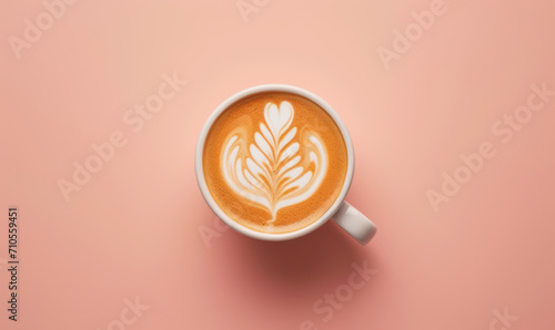 latte art coffee in white cup, top view on pastel pink background with copy space photo