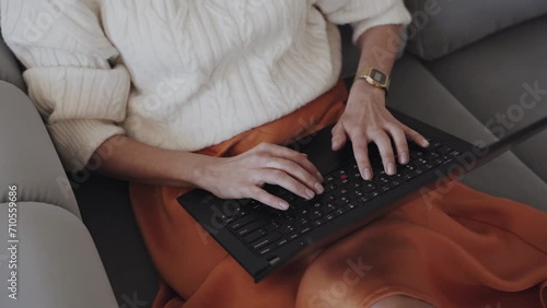 Crop faceless woman typing on laptop while working at home photo