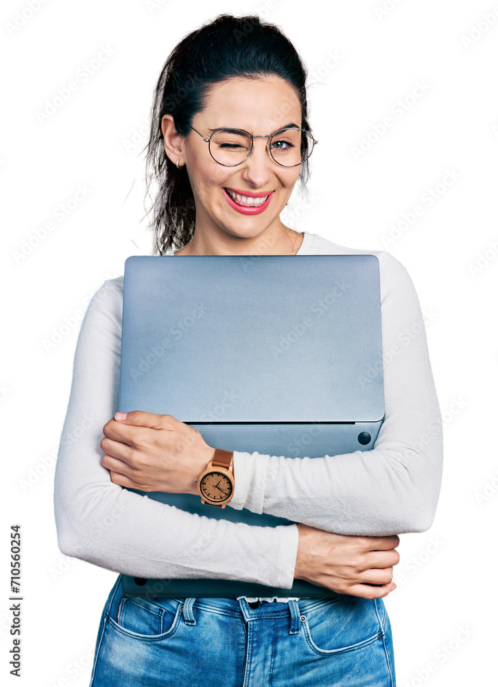 Young hispanic woman working using computer laptop winking looking at the camera with sexy expression, cheerful and happy face. Young hispanic woman working using computer laptop winking looking at the camera with sexy expression, cheerful and happy face.