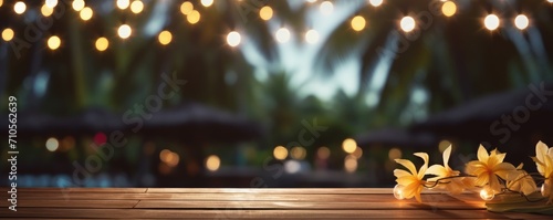blank wooden table with blurry tropical palm background decorated with fairy lights