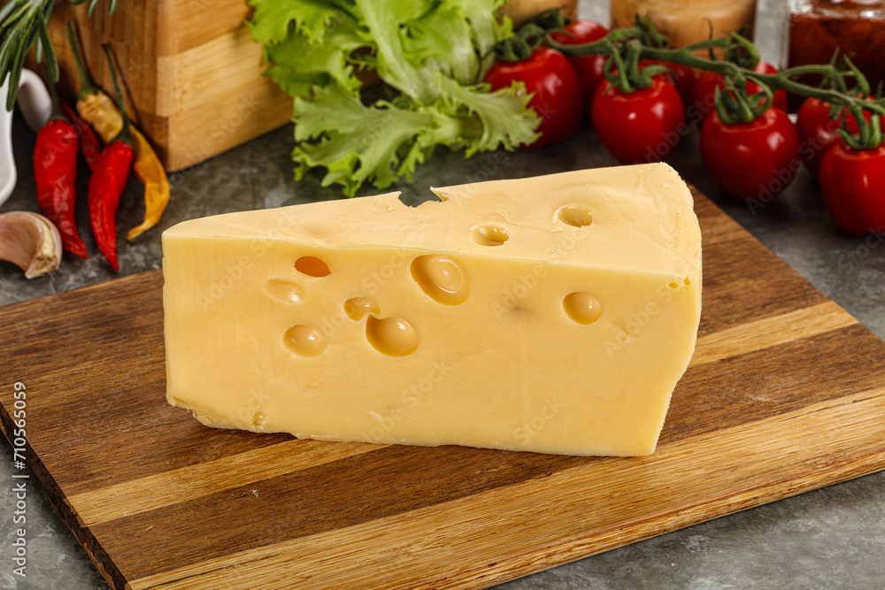 Swiss Maasdam cheese triangle over board Swiss Maasdam cheese triangle over board
