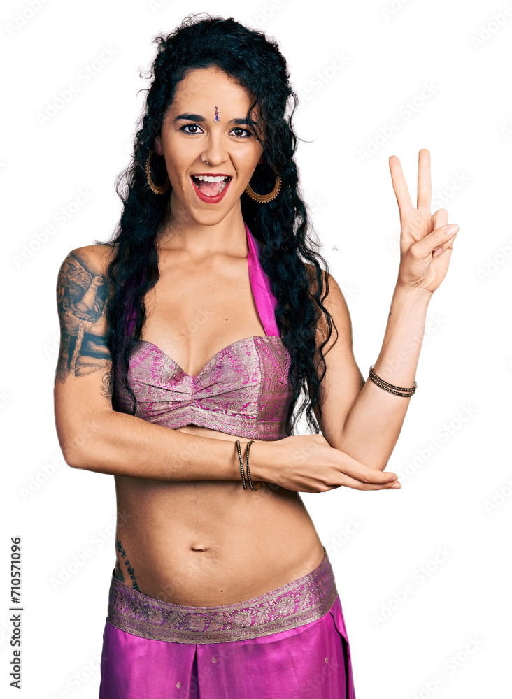 Φωτογραφία Young indian woman wearing belly dancer costume smiling with happy face winking at the camera doing victory sign with fingers