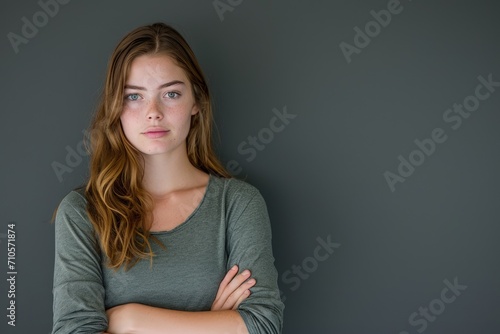 Woman Standing With Arms Crossed in Front of Gray Wall