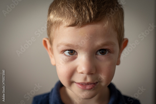 Retrato de niño pequeño rubio sonriendo mirando a la cámara 