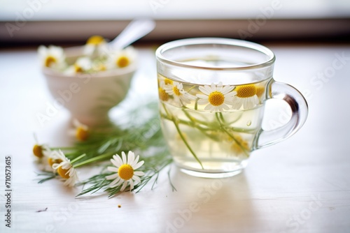 close-up of chamomile flowers in hot water, glass cup