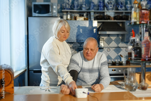 An elderly woman measures her husband s blood pressure
