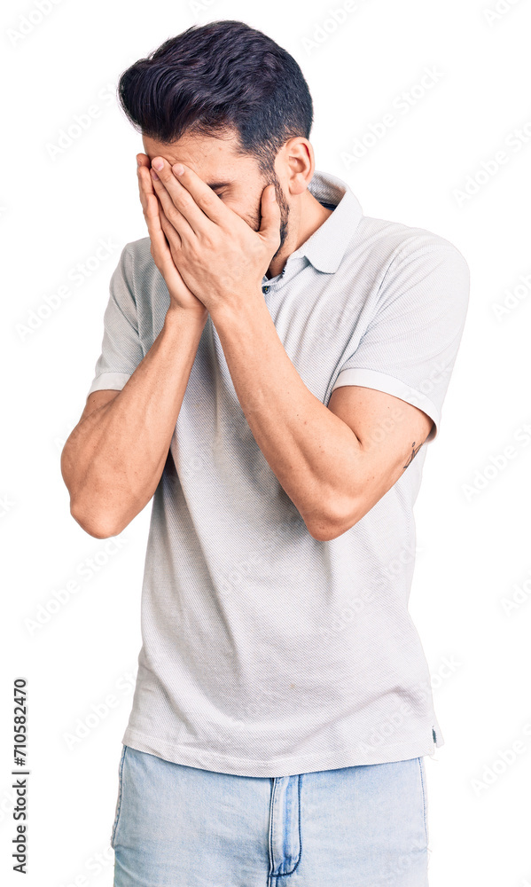 Young handsome man with beard wearing casual polo with sad expression covering face with hands while crying. depression concept. Young handsome man with beard wearing casual polo with sad expression covering face with hands while crying. depression concept.