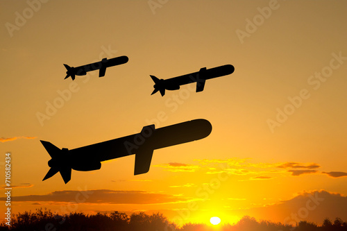 Silhouettes of Tomahawk cruise missiles against the sunset
