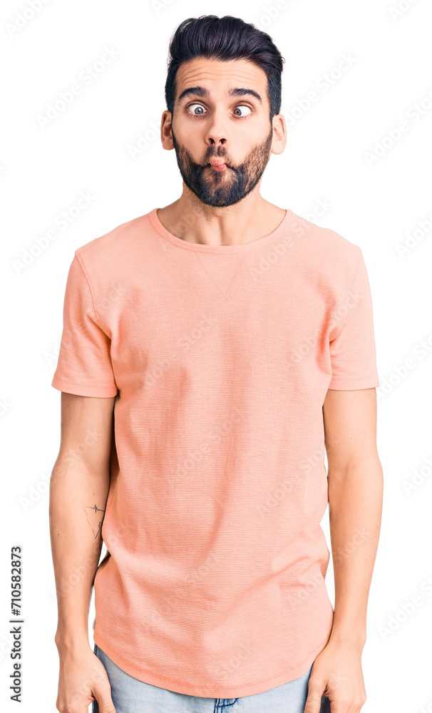 Young handsome man with beard wearing casual t-shirt making fish face with lips, crazy and comical gesture. funny expression. Young handsome man with beard wearing casual t-shirt making fish face with lips, crazy and comical gesture. funny expression.