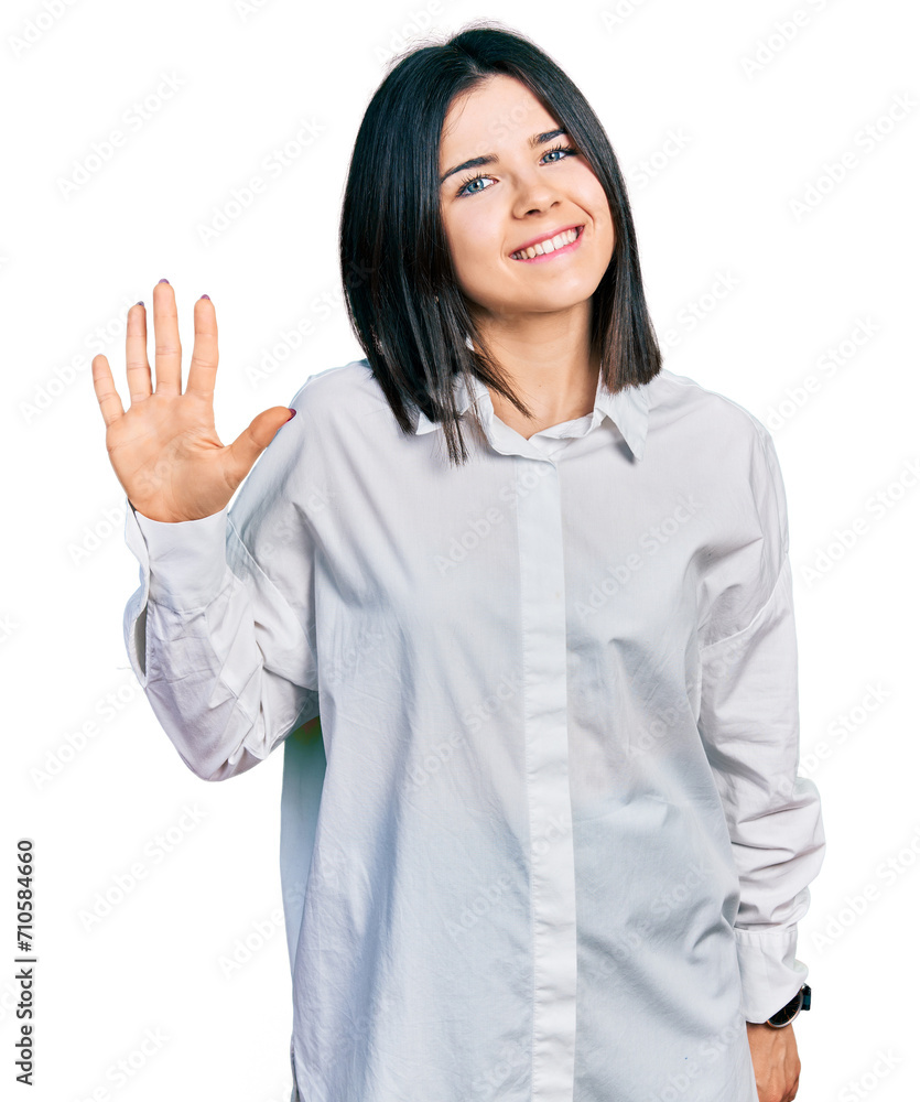 Young brunette woman with blue eyes wearing oversize white shirt showing and pointing up with fingers number five while smiling confident and happy. Young brunette woman with blue eyes wearing oversize white shirt showing and pointing up with fingers number five while smiling confident and happy.