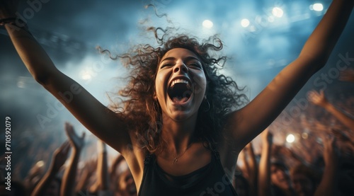 a female at a music concert with her arms up photo