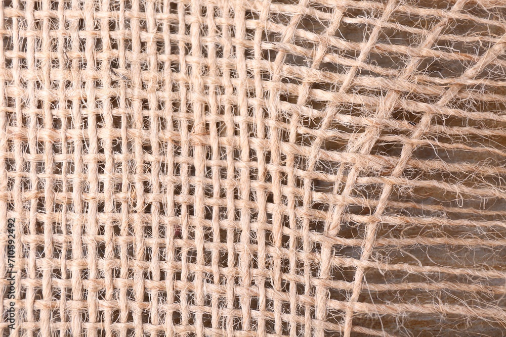 Piece of burlap fabric on wooden table, top view Piece of burlap fabric on wooden table, top view
