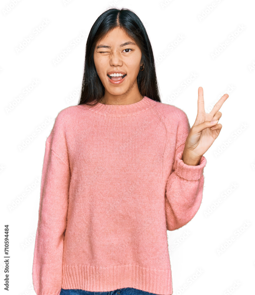 Beautiful young asian woman wearing casual winter sweater smiling with happy face winking at the camera doing victory sign. number two. Beautiful young asian woman wearing casual winter sweater smiling with happy face winking at the camera doing victory sign. number two.